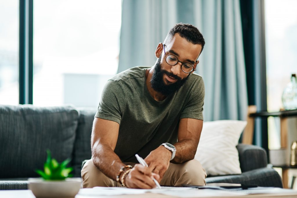 A thoughtful young adult on a personal development journey, looking inspired while planning their growth goals